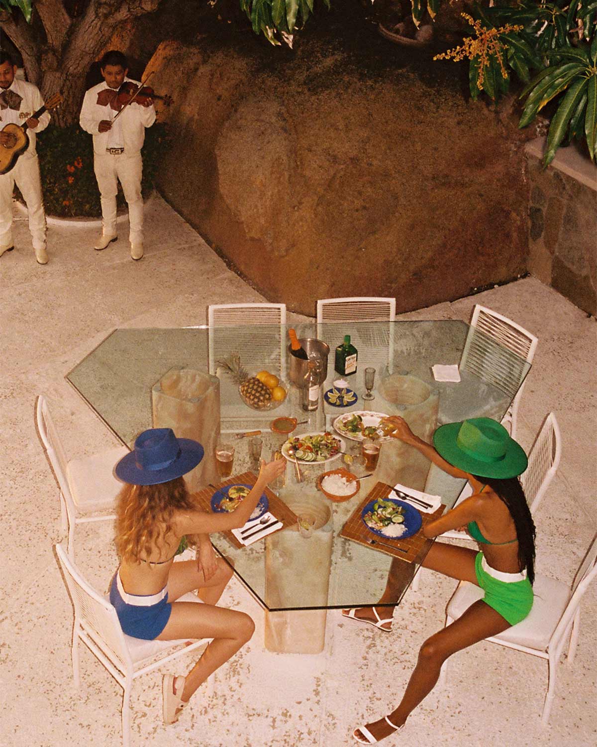 A sunlit lunch in wide-brim hats